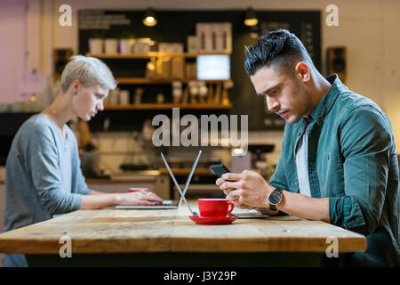 Mann und Frau arbeiten auf Laptops am Tisch im café Stockfoto