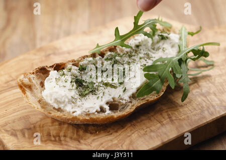 Rucola auf Bauernbrot mit Ricotta-Käse Stockfoto