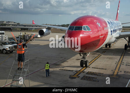 Flugzeug-Marschall mit Signalisierung-Sticks, um einen großen Passagier-Jet, eine exakte Position auf dem Vorfeld des Flughafen Tampa USA zu führen. Mai 2017 Stockfoto