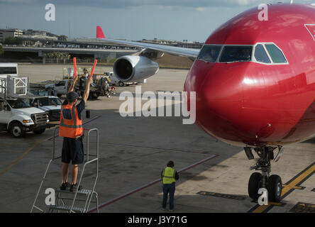 Flugzeug-Marschall mit Signalisierung-Sticks, um einen großen Passagier-Jet, eine exakte Position auf dem Vorfeld des Flughafen Tampa USA zu führen. Mai 2017 Stockfoto