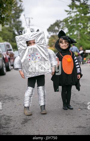 Porträt des jungen in Roboter-Kostüm und Mädchen im Hexenkostüm auf Straße Stockfoto