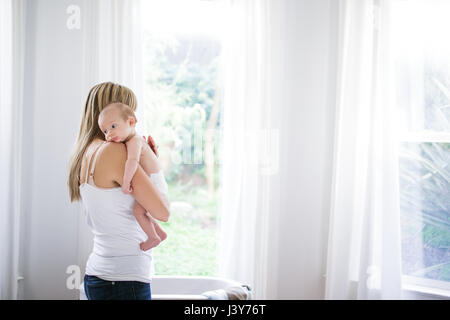 Mitte Erwachsene Frau mit Baby Sohn im Wohnzimmer Stockfoto