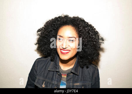 Porträt von lockigen Haaren Frau aussehende Weg Lächeln Stockfoto