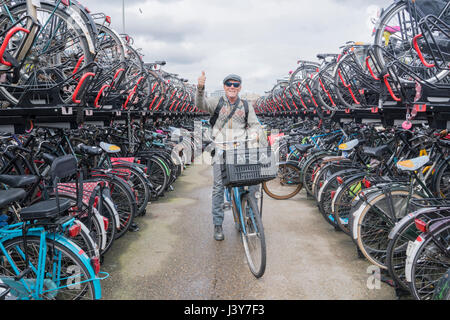 Radfahrer auf dem Fahrrad Blick in die Kamera geben Daumen nach oben, Amsterdam, Niederlande Stockfoto