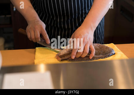 Ansicht der Koch in der Küche, die Zubereitung von Fisch abgeschnitten Stockfoto