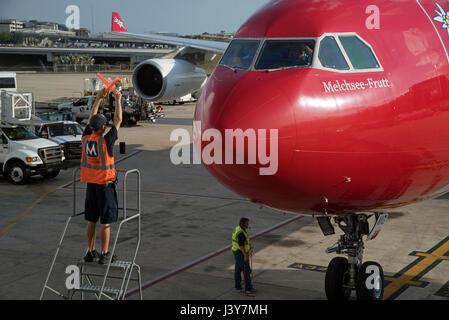 Flugzeug-Marschall mit Signalisierung-Sticks, um einen großen Passagier-Jet, eine exakte Position auf dem Vorfeld des Flughafen Tampa USA zu führen. Mai 2017 Stockfoto