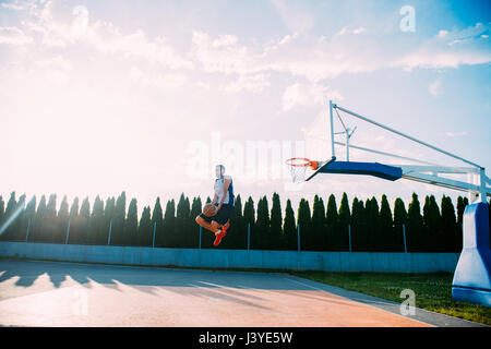 Junger Mann und eine fantastisches Slam Dunk spielen stree Stockfoto