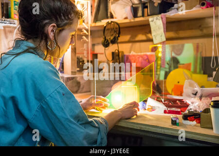 Junge Frau betrachten Materialien in einem Handwerksbetrieb Stockfoto