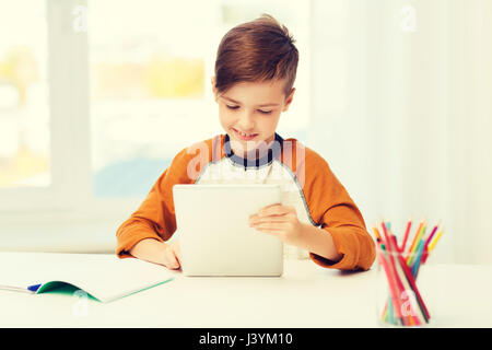 lächelnde junge mit TabletPC und Notebook zu Hause Stockfoto