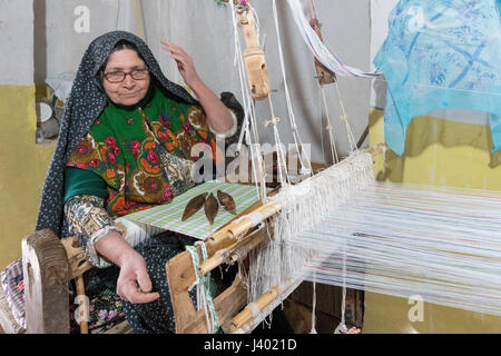 Begeisterte ältere Dame weben 8 Stunden am Tag für nur $30 Monat, Rooieen (Ruine), ein traditionelles Dorf, Nord-Chorasan, IRAN - 01 / Stockfoto