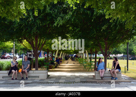 Öffentliche Sitzgelegenheiten unter Eichen und dekorative Bögen Linie, die die Promenade am Klyde Warren Park einer vertieften Autobahn in der Innenstadt von Dallas oberhalb Stockfoto