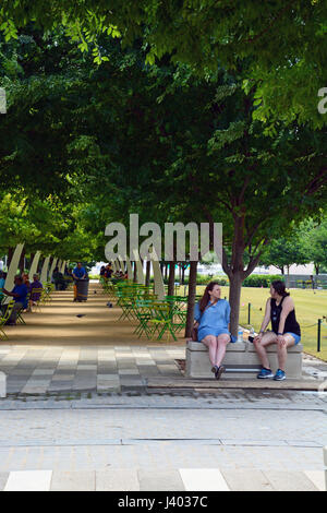 Öffentliche Sitzgelegenheiten unter Eichen und dekorative Bögen Linie, die die Promenade am Klyde Warren Park einer vertieften Autobahn in der Innenstadt von Dallas oberhalb Stockfoto