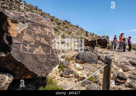 Eine Frau und mehrere Kinder betrachten Petroglyphen auf Petroglyph National Monument, New Mexico, Vereinigte Staaten Stockfoto