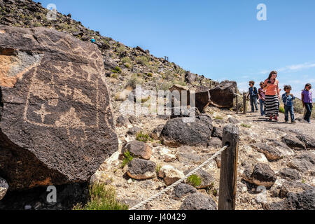 Eine Frau und mehrere Kinder touring Blick auf Felszeichnungen im Petroglyph National Monument, New Mexico, Vereinigte Staaten Stockfoto