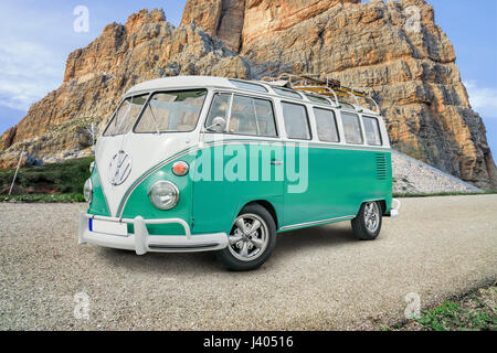 CORTINA DAMPEZZO, Italien – SEPTEMBER 23,2016: Historische VW-Bus mit Gepäck Rack vor einen großen Stein in den Dolomiten. Die Gepäck-Rack enthalten Stockfoto