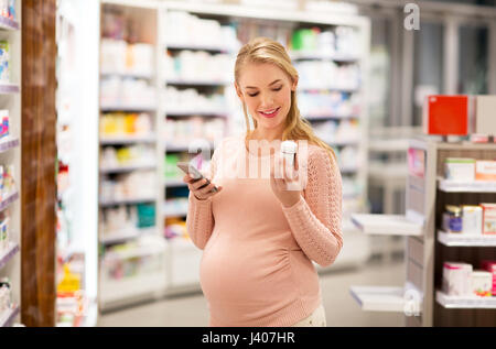 glücklich schwanger Frau mit Medikamenten in Apotheke Stockfoto