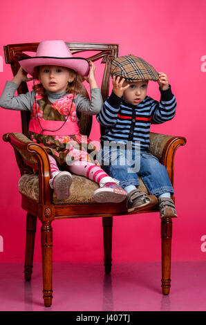 zwei Kinder Lächeln tragen Cowboyhüte, Studio Stockfoto