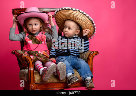 zwei Kinder Lächeln tragen Cowboyhüte, Studio Stockfoto