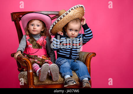 zwei Kinder Lächeln tragen Cowboyhüte, Studio Stockfoto