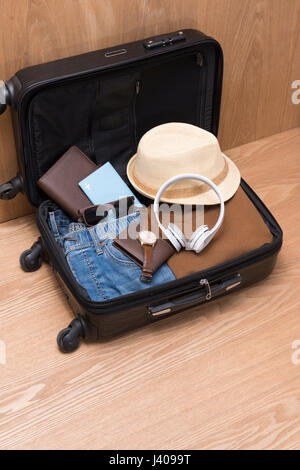 Reisen und Urlaub-Konzept. Öffnen des Reisenden Beutel mit Kleidung, Accessoires, Kreditkarte, Karten und Pass. Stockfoto