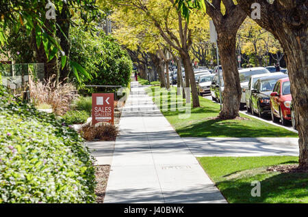 Los Angeles, USA - 9. März 2014: Bürgersteig auf Straße in der Innenstadt von LA in Beverly Hills mit Wohnhäusern und Bäumen Verkaufsgalerie Zeichen Stockfoto