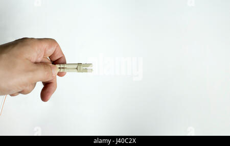 Glasfaserkabel in der Hand auf weißem Hintergrund. LC-Stecker für Fiber-to-home internet Stockfoto