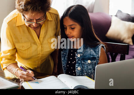 Großmutter helfen Enkelin bei den Hausaufgaben Stockfoto