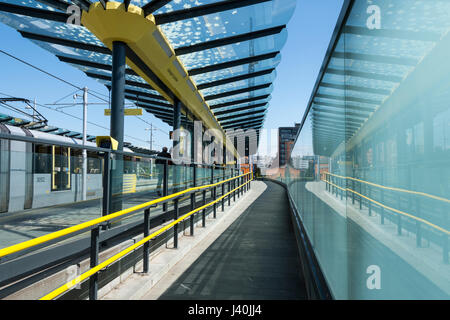 Metrolink Straßenbahn und Glas Wand bei Deansgate Castlefield Tram Stop, Manchester, England, UK Stockfoto