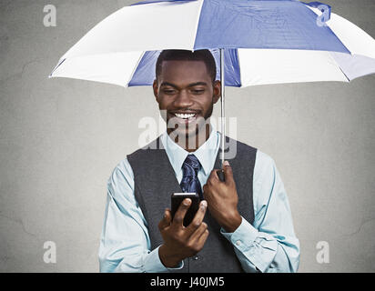 Closeup Portrait glücklich, Lächeln corporate Business-Mann, Executive lesen Nachricht Nachrichten auf Smartphone-Holding-Dach, geschützt vor Regen isoliert b