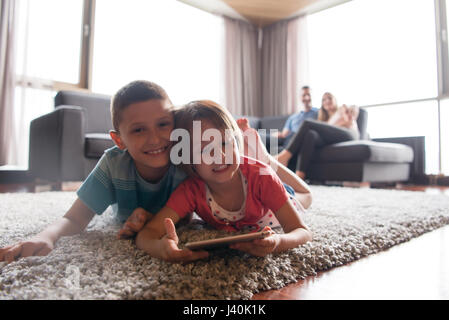 Happy Young Familie spielen gemeinsam am home.kids mit Tablet auf dem Boden Stockfoto