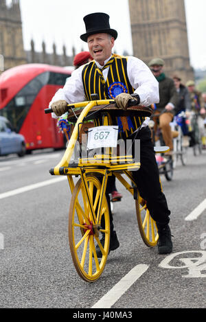Dandy Horse. Tweed Run Radfahrer in London überqueren die Westminster Bridge und passieren die Houses of Parliament Stockfoto