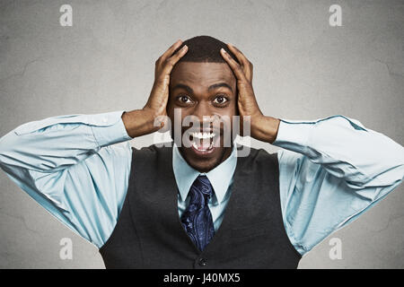 Closeup Portrait glücklich Jüngling, weit geöffneten Mund schauen schockiert, überrascht in voller Unglauben Hände auf Kopf, isoliert, schwarz grau hinterlegt. Positive Stockfoto