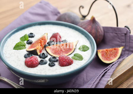Chia-Samen-Pudding mit Feigen, Himbeeren und Heidelbeeren in Schüssel auf Tablett Stockfoto