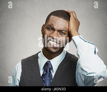 Porträt von verzweifelten Mann, auf graue Wand Hintergrund isoliert. Negative menschliche Mimik, Emotionen, Gefühle, Körpersprache, Wahrnehmung des Lebens Stockfoto