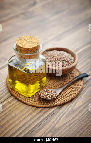 Leinsamen und Öl in der Flasche auf hölzernen Hintergrund Stockfoto