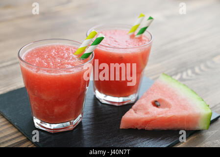 Wassermelonen-Smoothie in Glas mit Griff und Scheiben mit auf hölzernen Hintergrund Stockfoto
