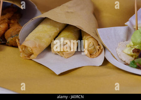 Garnelen, Kartoffeln und Gemüse in Teig, gebraten. Speiselokal in Kartonverpackung. Braten Sie, Pommes, Fisch und Gemüse. Stockfoto