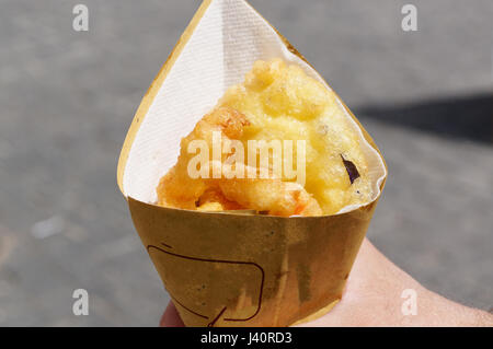 Garnelen, Kartoffeln und Gemüse in Teig, gebraten. Speiselokal in Kartonverpackung. Stockfoto