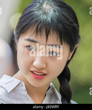 hübsche Frau/Asiatin mit langen schwarzen Zöpfen Stockfoto