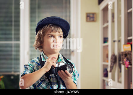 Niedliche kleine Junge in Retro-Outfit mit alten Film-Kamera fotografieren. Kreativität, lernen, kreative Freizeit für Kinder zu unterstützen. Stockfoto