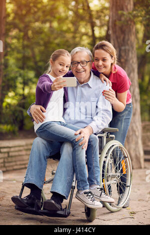 Familie Selfie Zeit im Park - Enkelin, Tochter und behinderte Menschen im Rollstuhl Stockfoto