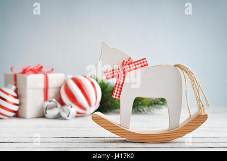 Spielzeugpferd mit Weihnachtsschmuck und Tanne auf blauem Hintergrund Stockfoto