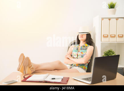 Business-Frau Tagträumen über ihre Ferien auf dem Stuhl im Büro schlafen. Urlaub und Reisen-Konzept mit gemischter Herkunft asiatische chinesische Modell. Stockfoto