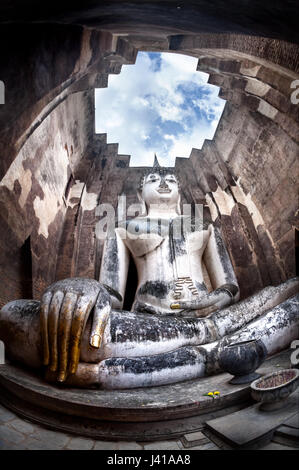 Riesige Buddha-Statue Phra Achana in Wat Si Chum in grau bedecktem Himmel in Sukhothai Historical Park, Thailand anrufen Stockfoto