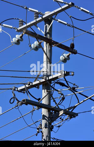 Kreuzung der elektrischen Leitungen mit Isolatoren auf Alter Holzstab. Stockfoto