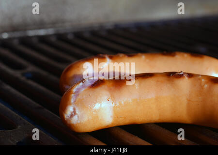 Zwei Würste auf Grill. Fokus auf Vordergrund. Schließen Sie herauf horizontale Bild. Stockfoto