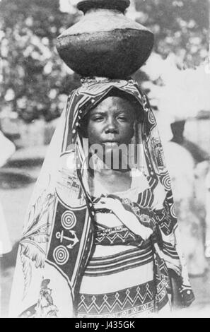 Ein Foto einer Frau von den Komoren, aufgenommen 1908 in Madagaskar. Das Bild fängt ihre Kleidung und ihr kulturelles Erbe ein und spiegelt die regionalen Einflüsse dieser Zeit wider. Stockfoto