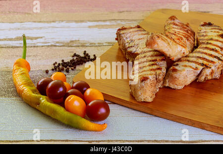 Schweineschnitzel mit Gemüse Nahaufnahme auf Papier, horizontale Ansicht von oben, rustikalen Stil Stockfoto