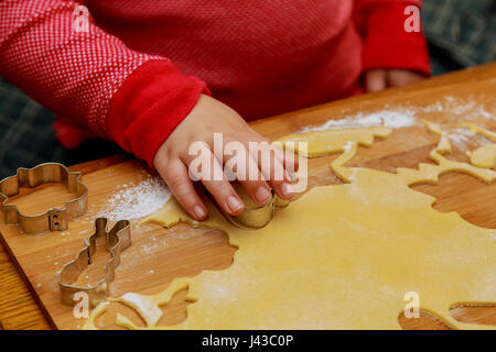 Draufsicht der Schneiden Lebkuchen von Metallformen von Kinderhand Stockfoto