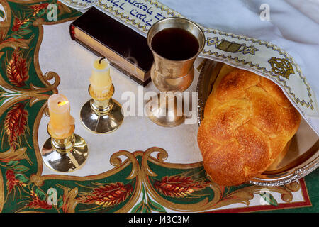 Schabbat-Kerzen im Glas-Leuchter mit unscharfen überdachte Challah Hintergrund. Geringe Schärfentiefe hautnah Stockfoto